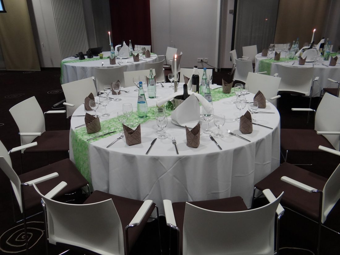 Round tables laid for an evening reception at a previous Zenith Group event